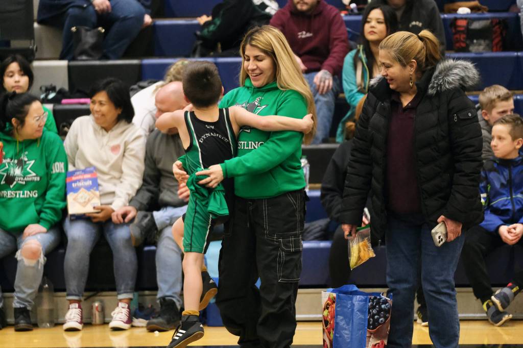 A youth wrestler jumps into his mothers arms during Saturdays elementary school age wrestling tournament at Thunder Mountain Middle School. (Klas Stolpe / Juneau Empire)