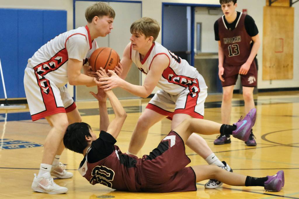 Klawock seniors Thomas Teal and Tanner Smith steal a loose ball from Hoonah eighth grade Gabe Contreras (30) in the Chieftains 68-31 win over the Braves during the 2025 Alaska Airlines Region V 1A Boys Basketball Tournament at Thunder Mountain Middle School. (Klas Stolpe / Juneau Empire)