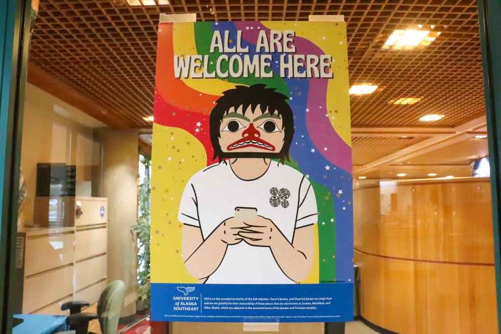 A poster designed by Chloey Cavanaugh, an Indigenous and queer Juneau business owner, is found around campus with the words all are welcome here. (Jasz Garrett / Juneau Empire)