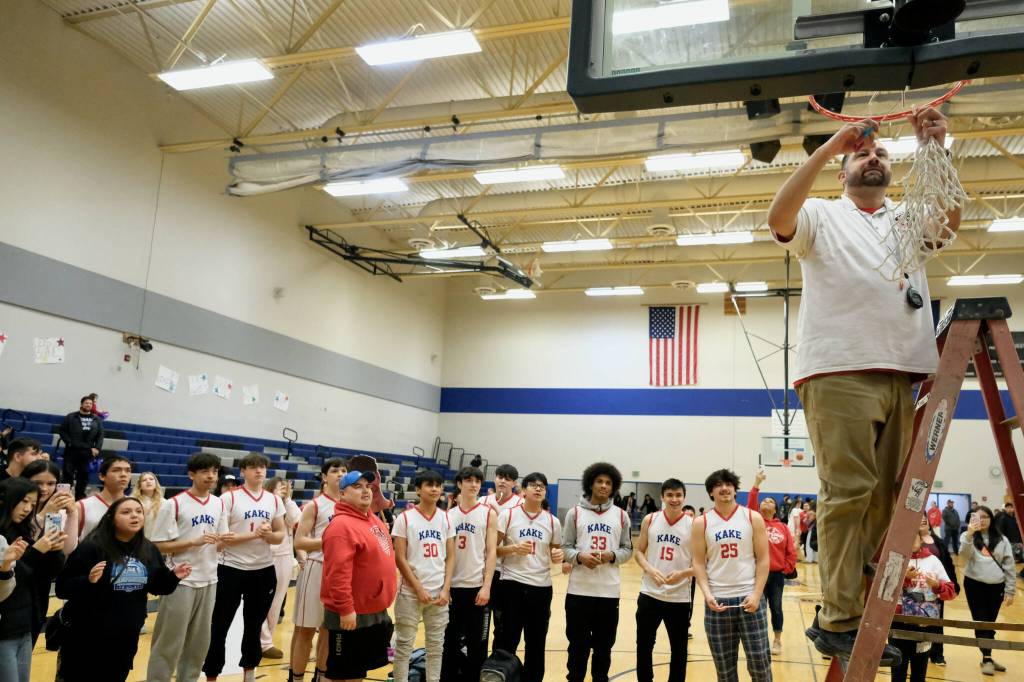 Kake coach Anthony Ross cuts down the net after the Thunderbirds’ 56-40 win over the Klawock Chieftains on Friday during the Region V 1A Boys Basketball Tournament Championship game at Thunder Mountain Middle School. (Klas Stolpe / Juneau Empire)