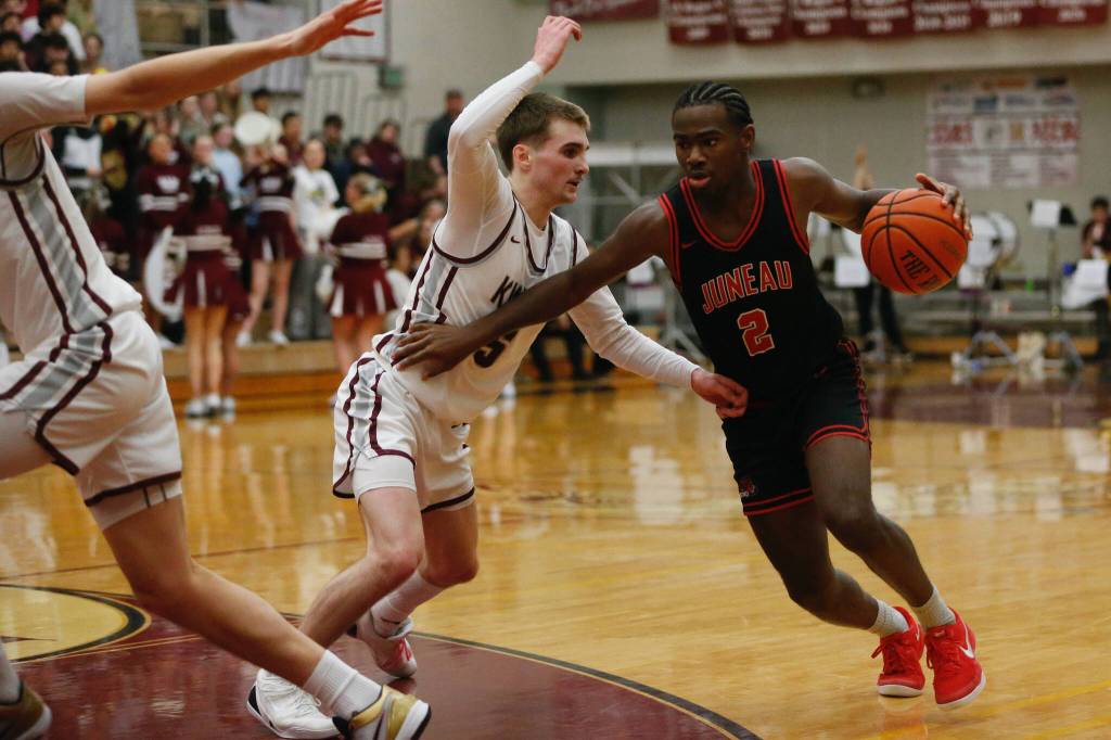 Juneau-Douglas High School: Yadaa.at Kalés Amir Parker runs around Ketchikans Gage Massin during Ketchikans 74-54 victory over Juneau-Douglas, winning the Region V 4A Basketball Tournament at the Clarke Cochrane Gymnasium on Friday. Ketchikan eliminated Juneau-Douglas and will advance to play at state. (Christopher Mullen / Ketchikan Daily News)