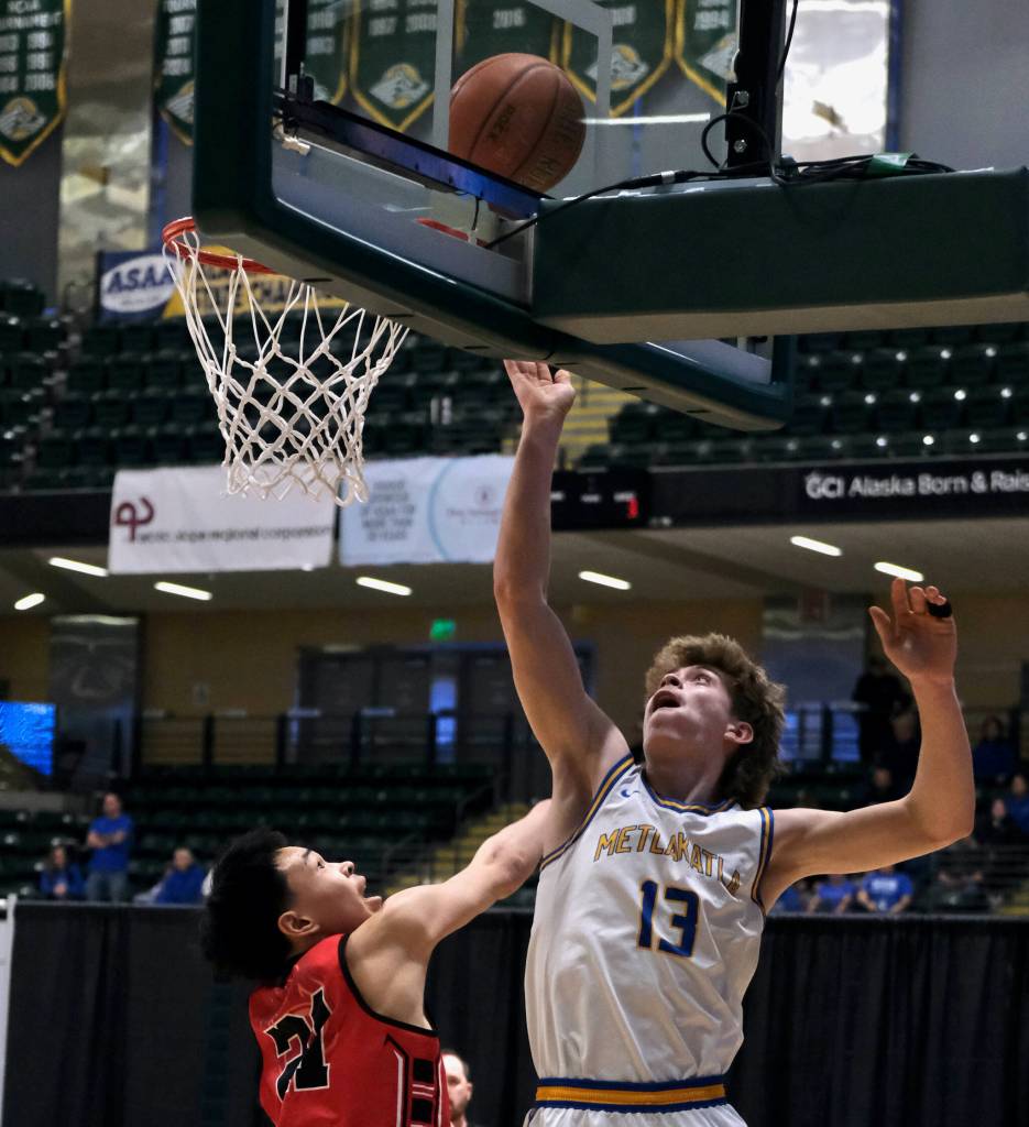 Metlakatlas Carter Marsden lays a shot off the glass over Chevaks Anthony Martins (21) in the Chiefs 63-33 win over the Comets in the 2025 ASAA March Madness Alaska 1A/2A State Basketball Championships on Thursday at Anchorages Alaska Airlines Center (Klas Stolpe / Juneau Empire)