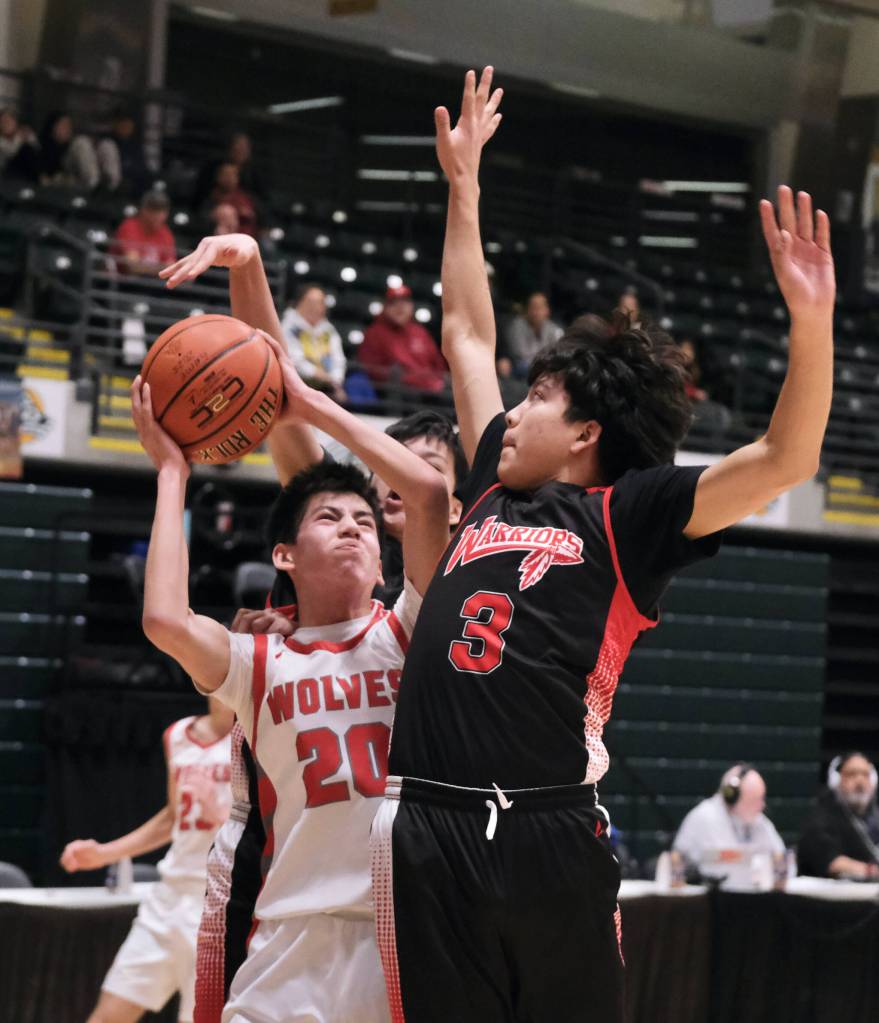 Wrangells Kyan Stead (20) powers up a shot against Effie Kokrine defender Esai Joseph (1) in the Wolves 75-40 win over the Warriors on Friday in the 2025 ASAA March Madness Alaska 2A State Basketball Championships at Anchorages Alaska Airlines Center (Klas Stolpe / Juneau Empire)