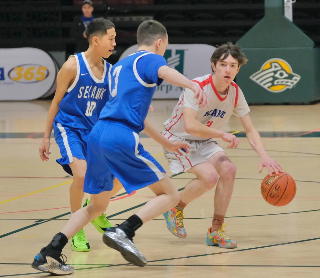 Kakes Talen Davis (3) brings the ball up court against Davis Ramoth defenders Ralph Stalker (10) and Cristopher Hanshaw (13) during the Thunderbirds 61-53 win over the Wolves on Friday in the 2025 ASAA March Madness Alaska 1A State Basketball Championships at Anchorages Alaska Airlines Center (Klas Stolpe / Juneau Empire)