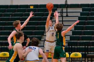 Metlakatla senior Brody Booth (12) scores over Sewards Lane Petersen and Jack Lindquisst (1) during their 3rd/5th-place game Saturday at the 2025 ASAA March Madness Alaska 2A State Basketball Championships at UAAs Avis Sports Center. (Klas Stolpe / Juneau Empire)