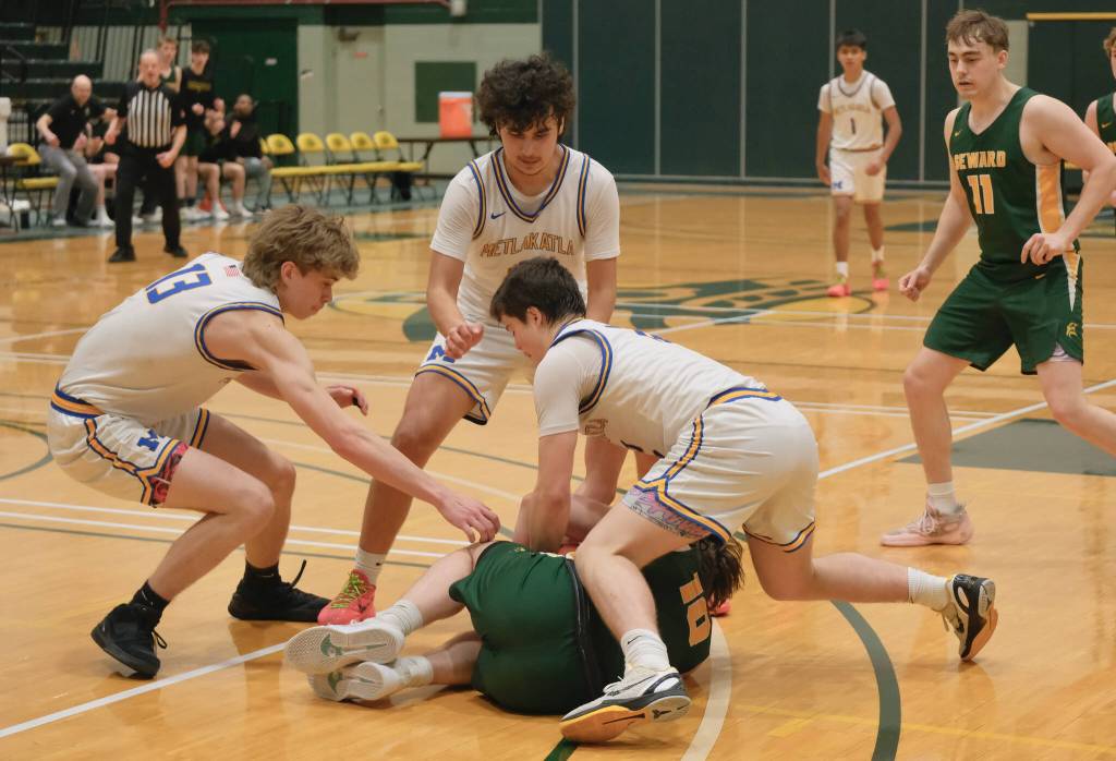 Metlakatla seniors Carter Marsden (13), Frank Guthrie and Brody Booth scrap for a loose ball with Sewards Emerson Cross (10) during their 3rd/5th-place game Saturday at the 2025 ASAA March Madness Alaska 2A State Basketball Championships at UAAs Avis Sports Center. (Klas Stolpe / Juneau Empire)