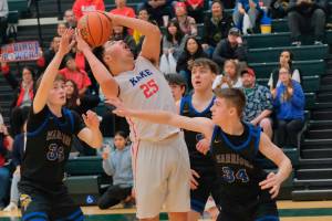 Kakes Aiden Clark (25) puts up a shot against Tri-Valleys Kole Lucas (33), Reid Williams (2) and Henry Miner (34) during their 4th/6th-place game Saturday at the 2025 ASAA March Madness Alaska 1A State Basketball Championships at Anchorages Alaska Airlines Center. (Klas Stolpe / Juneau Empire)