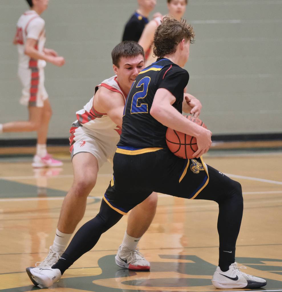 Wrangell senior Daniel Harrison attempts to steal a ball from Susitna Valleys Austin Barnard (12) during the Wolves 53-50 loss to the Rams in the 4th/6th-place game Saturday at the 2025 ASAA March Madness Alaska 2A State Basketball Championships at UAAs Avis Sports Center. (Klas Stolpe / Juneau Empire)
