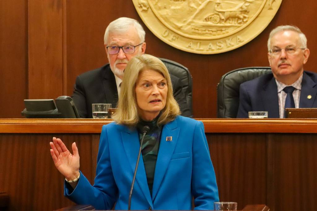 U.S. Sen. Lisa Murkowski raises her right hand to demonstrate the oath she took while answering a question about her responsibility to defend the U.S. Constitution during her annual address to the Alaska Legislature on March 18, 2025. (Jasz Garrett / Juneau Empire)