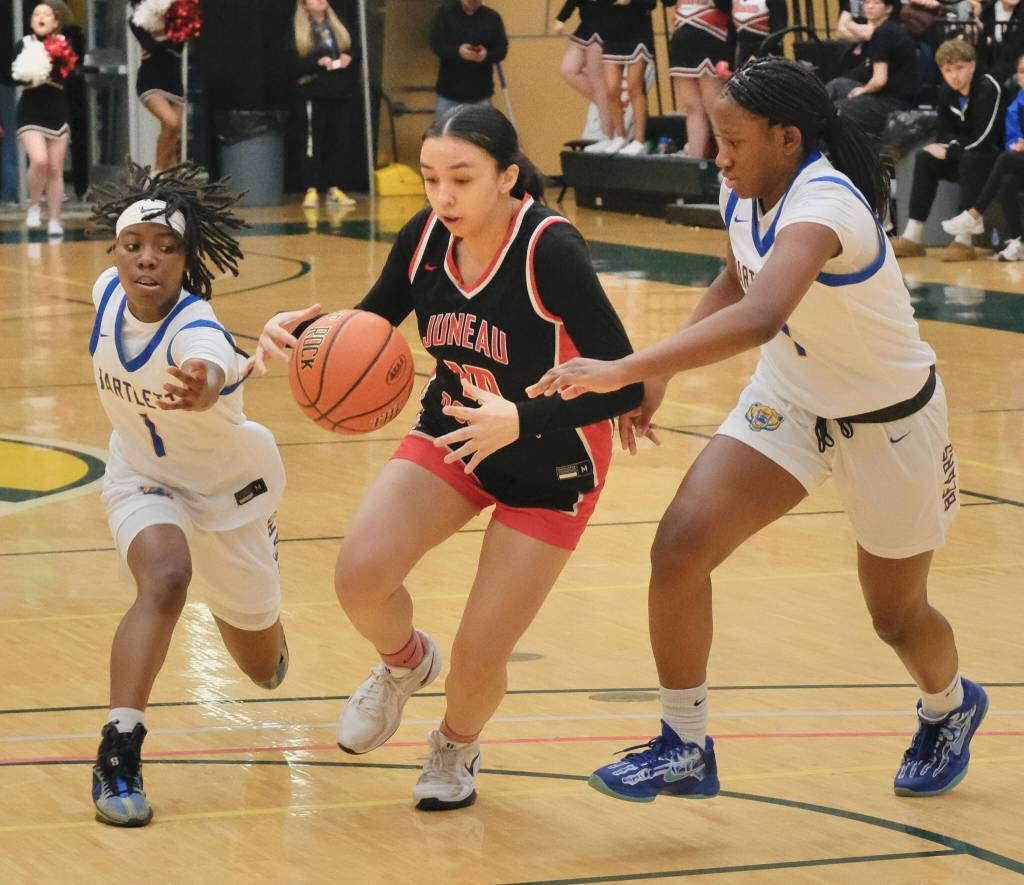 Juneau-Douglas High School: Yadaa.at Kalé senior Addison Wilson (10) secures a ball under pressure from Bartlett freshmen Kennedi Gaines (1) and Nahliah Houston (4) during the Crimson Bears