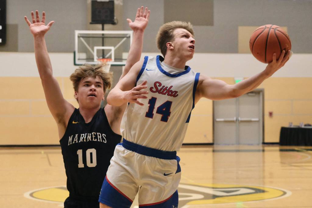 Sitka senior Trey Demmert (14) scores past Homer senior Preston Stanislaw (10) during the Wolves 61-26 win over the Mariners on Wednesday at the 2025 ASAA March Madness Alaska 3A/4A Basketball State Championships at Anchorages Alaska Airlines Center. (Klas Stolpe / Juneau Empire)