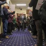 U.S. Sen. Dan Sullivan (R-Alaska) walks through a hallway of protesters with his wife, Julie Fate Sullivan, before his annual address to the Alaska Legislature on Thursday, March 20, 2025. (Jasz Garrett / Juneau Empire)