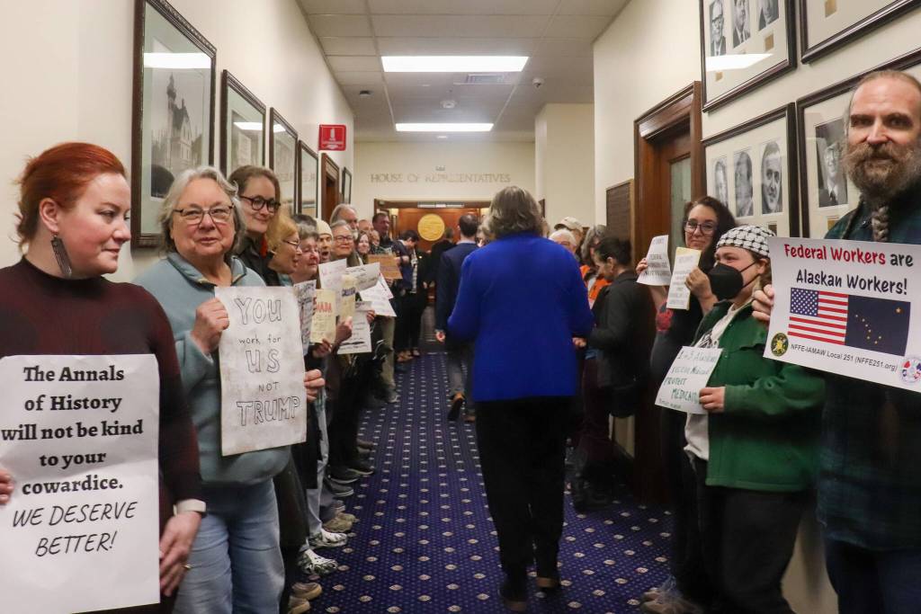 Rep. Sara Hannan (D-Juneau) walks past Juneau residents protesting U.S. Sen. Dan Sullivan (R-Alaska) before his annual address to the Alaska Legislature on Thursday, March 20, 2025. (Jasz Garrett / Juneau Empire)