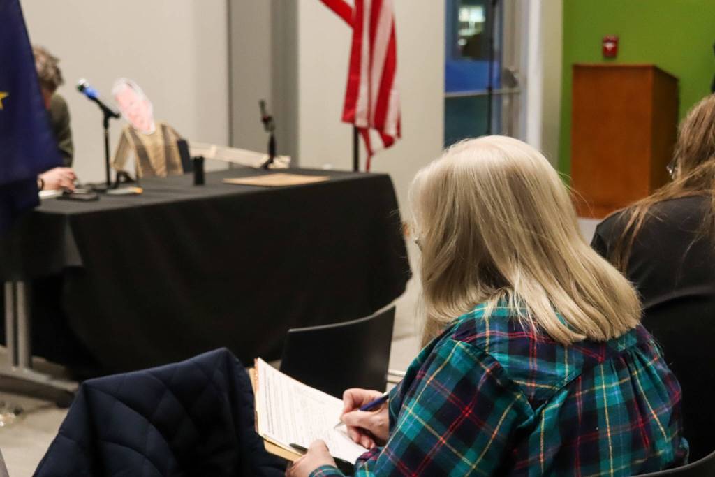 A Juneau resident signs a petition asking Sullivan to unequivocally support Ukraine at an empty-chair town hall on Thursday, March 20, 2025. (Jasz Garrett / Juneau Empire)