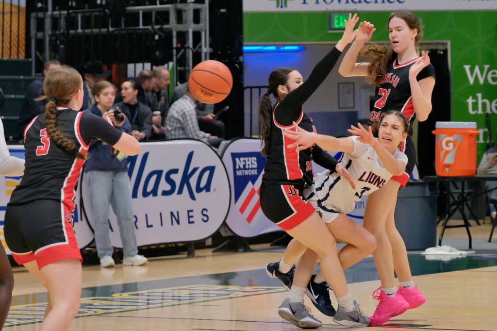 JDHS junior Cambry Lockhart (3) intercepts a pass forced by sophomore Layla Tokuoka and senior Cailynn Baxter (23) on Mountain City Christian Academys Morgan Maldonaldo (3) during the Crimson Bears 57-37 loss to the Lions in the 3rd/5th place game Saturday at 2025 ASAA March Madness Alaska 4A Basketball State Championships in Anchorages Alaska Airlines Center. (Klas Stolpe / Juneau Empire)