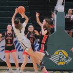 JDHS junior Cambry Lockhart (3), sophomore Layla Tokuoka and seniors Cailynn Baxter (23) and Kerra Baxter (22) defend Mountain City Christian Academys Morgan Maldonaldo (3) during the Crimson Bears 57-37 loss to the Lions in the 3rd/5th-place game Saturday at 2025 ASAA March Madness Alaska 4A Basketball State Championships in Anchorages Alaska Airlines Center. (Klas Stolpe / Juneau Empire)