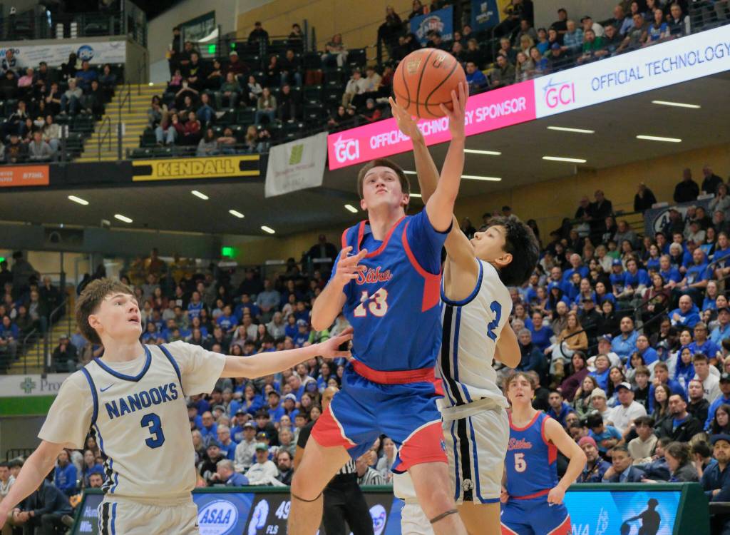 Sitka junior Shane Tincher shoots under pressure from Nomes Orson Hoogendorn (3) and Lane Schuerch (2) during the Wolves 62-43 loss to the Nanooks on Saturday in the 3A championship game of the 2025 ASAA March Madness Alaska 3A Basketball State Championships in Anchorages Alaska Airlines Center. (Klas Stolpe / Juneau Empire)