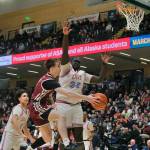 Ketchikan senior Gage Massin passes around East Anchorage senior Jai Tharjiath (32) during the Kings 43-25 loss to the Thunderbirds on Saturday in the 4A championship game of the 2025 ASAA March Madness Alaska 4A Basketball State Championships in Anchorages Alaska Airlines Center. (Klas Stolpe / Juneau Empire)
