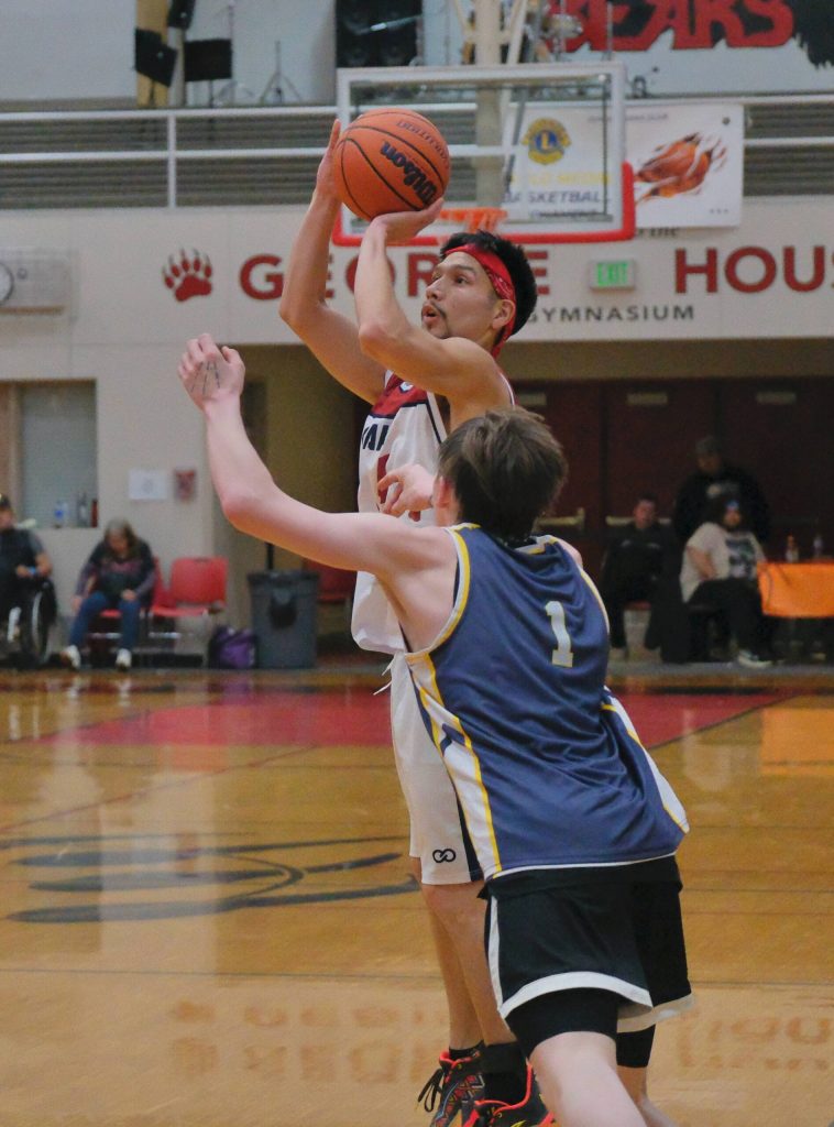 Kakes Simon Friday shoots from past the arc over Ketchikans Archie Dundas (10) in B Bracket action Sunday at the 76th Annual Juneau Lions Club Gold Medal Basketball Tournament in Juneau-Douglas High School: Yadaa.at Kalés George Houston Gymnasium. (Klas Stolpe / Juneau Empire)