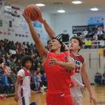 Hoonahs Kayden Lamebull-Ingram (11) shoots under pressure from Kakes Diminic Ross (21) during Hoonahs 84-66 B Bracket win Monday at the 76th Annual Juneau Lions Club Gold Medal Basketball Tournament in Juneau-Douglas High School: Yadaa.at Kalés George Houston Gymnasium. (Klas Stolpe / Juneau Empire)