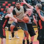 Metlakatlas Willie Hayward floats through Klukwan defenders Dave Buss (22), Erik McCormick (6) and Andrew Friske (12) during Masters Bracket action Monday at the 76th Annual Juneau Lions Club Gold Medal Basketball Tournament in Juneau-Douglas High School: Yadaa.at Kalés George Houston Gymnasium. (Klas Stolpe / Juneau Empire)