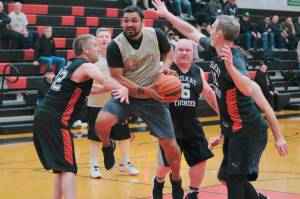 Metlakatlas Willie Hayward floats through Klukwan defenders Dave Buss (22), Erik McCormick (6) and Andrew Friske (12) during Masters Bracket action Monday at the 76th Annual Juneau Lions Club Gold Medal Basketball Tournament in Juneau-Douglas High School: Yadaa.at Kalés George Houston Gymnasium. (Klas Stolpe / Juneau Empire)
