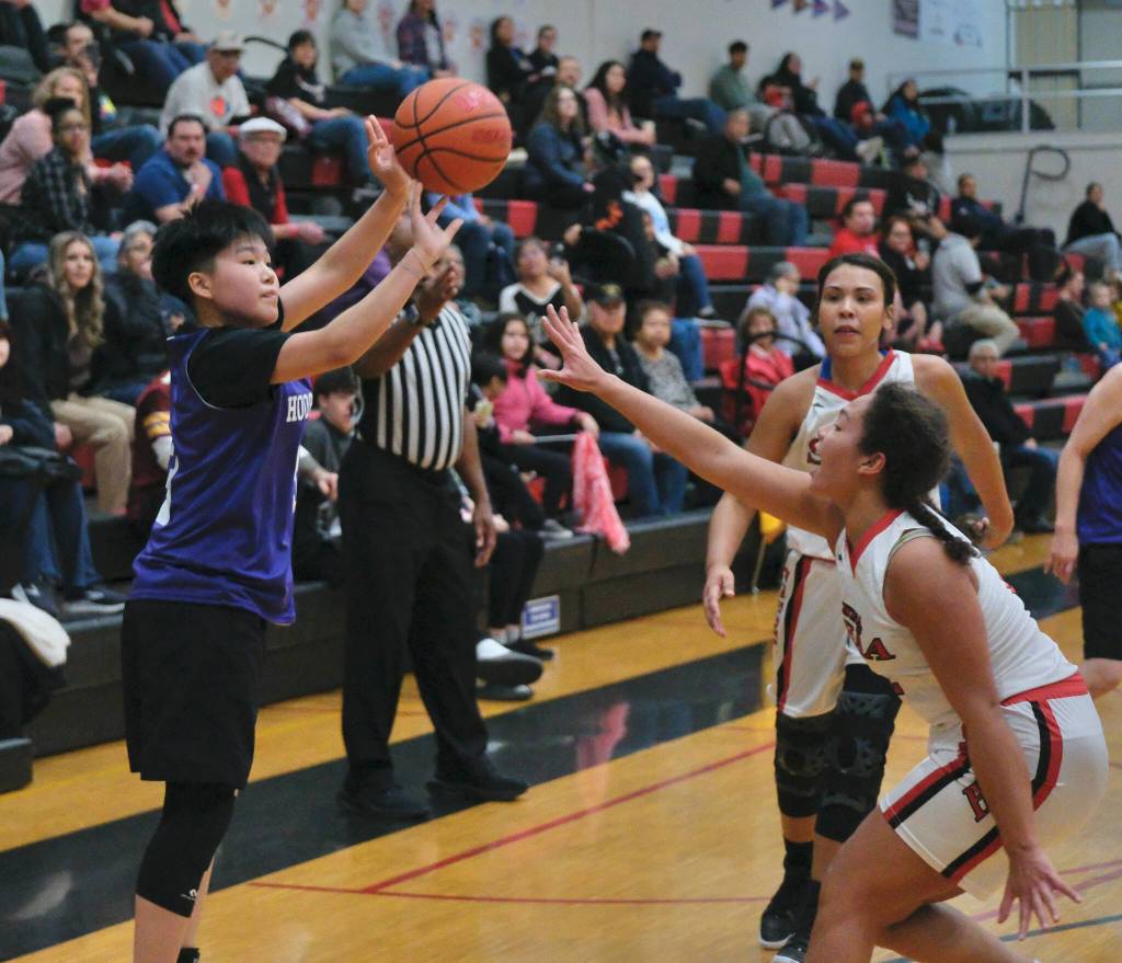 Hooper Bays Susie Long (3) shoots from past the arc over Hoonahs Antonia Fogg and Jonelle Stavland (back) in Womens Bracket play Monday at the 76th Annual Juneau Lions Club Gold Medal Basketball Tournament in Juneau-Douglas High School: Yadaa.at Kalés George Houston Gymnasium. (Klas Stolpe / Juneau Empire)