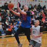 Sitkas Sid Eubanks (6) scores past Angoons Frank Lane (21) during Sitkas 63-36 Masters Bracket win Monday at the 76th Annual Juneau Lions Club Gold Medal Basketball Tournament in Juneau-Douglas High School: Yadaa.at Kalés George Houston Gymnasium. (Klas Stolpe / Juneau Empire)