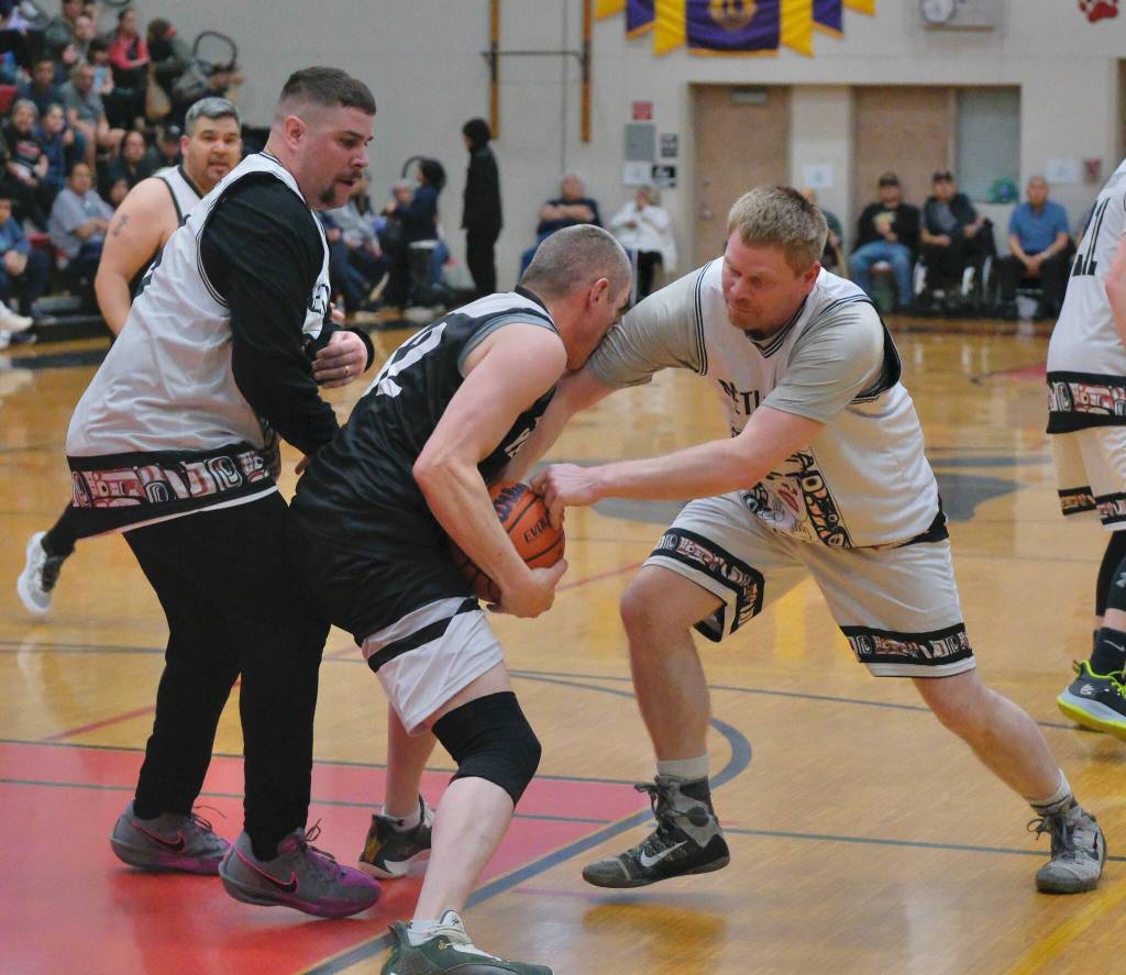 Metlakatlas Jase Scudero and Apollo Marsden try to tie up Yakutats Jimmi Jensen during C Bracket action Monday at the 76th Annual Juneau Lions Club Gold Medal Basketball Tournament in Juneau-Douglas High School: Yadaa.at Kalés George Houston Gymnasium. (Klas Stolpe / Juneau Empire)