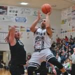 Metlakatlas Chris Bryant scores under pressure from Yakutats Dustin Endicott (8) during their 49-47 C Bracket win Monday at the 76th Annual Juneau Lions Club Gold Medal Basketball Tournament in Juneau-Douglas High School: Yadaa.at Kalés George Houston Gymnasium. (Klas Stolpe / Juneau Empire)