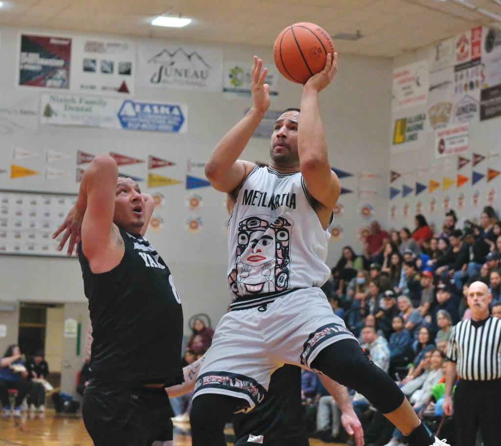 Metlakatlas Chris Bryant scores under pressure from Yakutats Dustin Endicott (8) during their 49-47 C Bracket win Monday at the 76th Annual Juneau Lions Club Gold Medal Basketball Tournament in Juneau-Douglas High School: Yadaa.at Kalés George Houston Gymnasium. (Klas Stolpe / Juneau Empire)