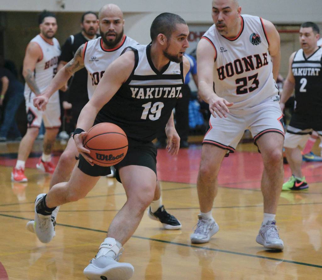 Yakutats Alan Vale (19) dribbles against Hoonahs Tavis Dybdahl (23) during Hoonahs 75-43 C Bracket elimination game win Tuesday at the 76th Annual Juneau Lions Club Gold Medal Basketball Tournament in Juneau-Douglas High School: Yadaa.at Kalés George Houston Gymnasium. (Klas Stolpe / Juneau Empire)