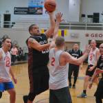 Hoonahs Jeremy Martin shoots against Sitkas Mitch Mork as Sitkas Tom Anderson and Matt Love, and Hoonahs Andy Grey move in during their Masters Bracket elimination game Tuesday at the 76th Annual Juneau Lions Club Gold Medal Basketball Tournament in Juneau-Douglas High School: Yadaa.at Kalés George Houston Gymnasium. (Klas Stolpe / Juneau Empire)