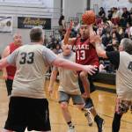 Kakes Jay Peterson (13) scores among Metlakatlas Danny Marsden (33), Archie Dundas and Steve Booth (42) during Kakes 62-48 Masters Bracket win Tuesday at the 76th Annual Juneau Lions Club Gold Medal Basketball Tournament in Juneau-Douglas High School: Yadaa.at Kalés George Houston Gymnasium. (Klas Stolpe / Juneau Empire)