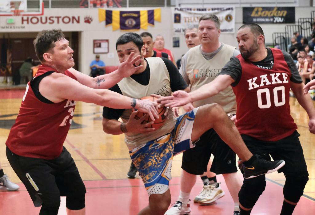 Metlakatlas Willie Hayward secures rebound under pressure from Kakes Jess Ross and Anthony Ross (00) during Kakes 62-48 Masters Bracket win Tuesday at the 76th Annual Juneau Lions Club Gold Medal Basketball Tournament in Juneau-Douglas High School: Yadaa.at Kalés George Houston Gymnasium. (Klas Stolpe / Juneau Empire)