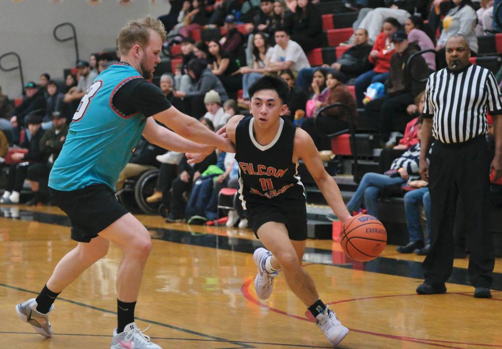 Juneau-AMLs Cody Grussendorf (13) defends Filcoms Alwen Carrillo (11) during Juneau-AMLs 90-58 A Bracket elimination game win Wednesday at the 76th Annual Juneau Lions Club Gold Medal Basketball Tournament in Juneau-Douglas High School: Yadaa.at Kalés George Houston Gymnasium. (Klas Stolpe / Juneau Empire)