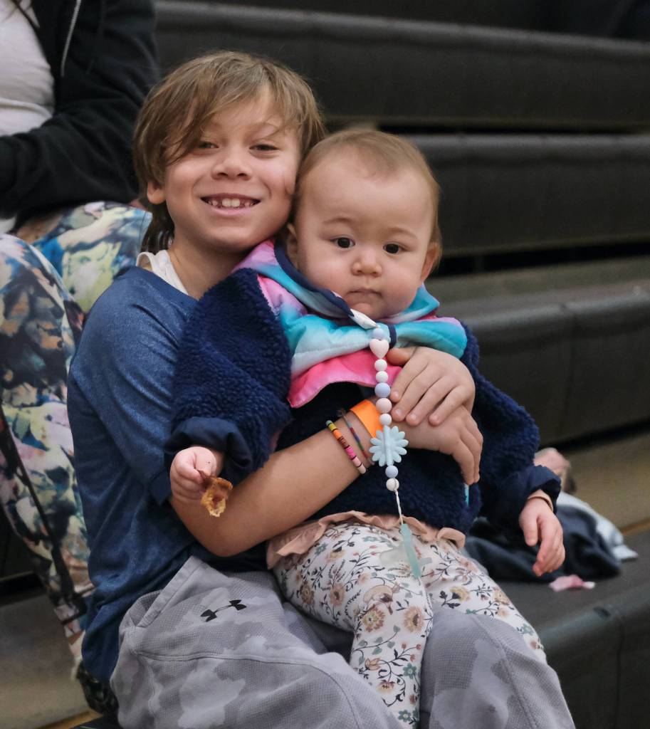 Erick Waters holds Milcah Waters during action Wednesday at the 76th Annual Juneau Lions Club Gold Medal Basketball Tournament in Juneau-Douglas High School: Yadaa.at Kalés George Houston Gymnasium. (Klas Stolpe / Juneau Empire)