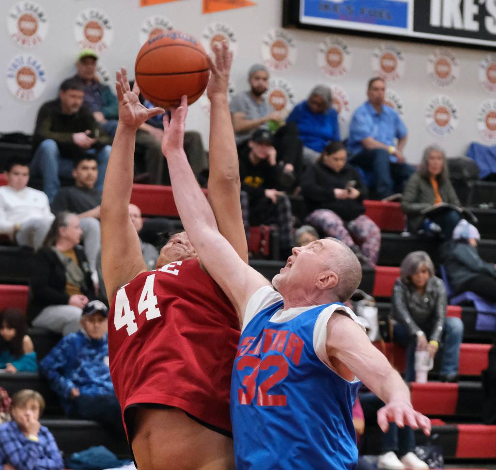 Sitkas Norm Staton (32) and Kakes Burt Jackson (44) go for a rebound during Sitkas 87-46 Masters Bracket elimination game win Thursday at the 76th Annual Juneau Lions Club Gold Medal Basketball Tournament in Juneau-Douglas High School: Yadaa.at Kalés George Houston Gymnasium. (Klas Stolpe / Juneau Empir