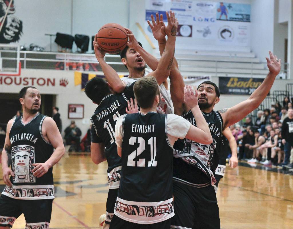 Hydaburgs Darren Edenshaw powers a shot through Metlakatlas Bradley Martinez (11), Jason Enright (21) and Bryan Hayward during Metlakatlas 74-65 C Bracket semifinal win Thursday at the 76th Annual Juneau Lions Club Gold Medal Basketball Tournament in Juneau-Douglas High School: Yadaa.at Kalés George Houston Gymnasium. (Klas Stolpe / Juneau Empire)