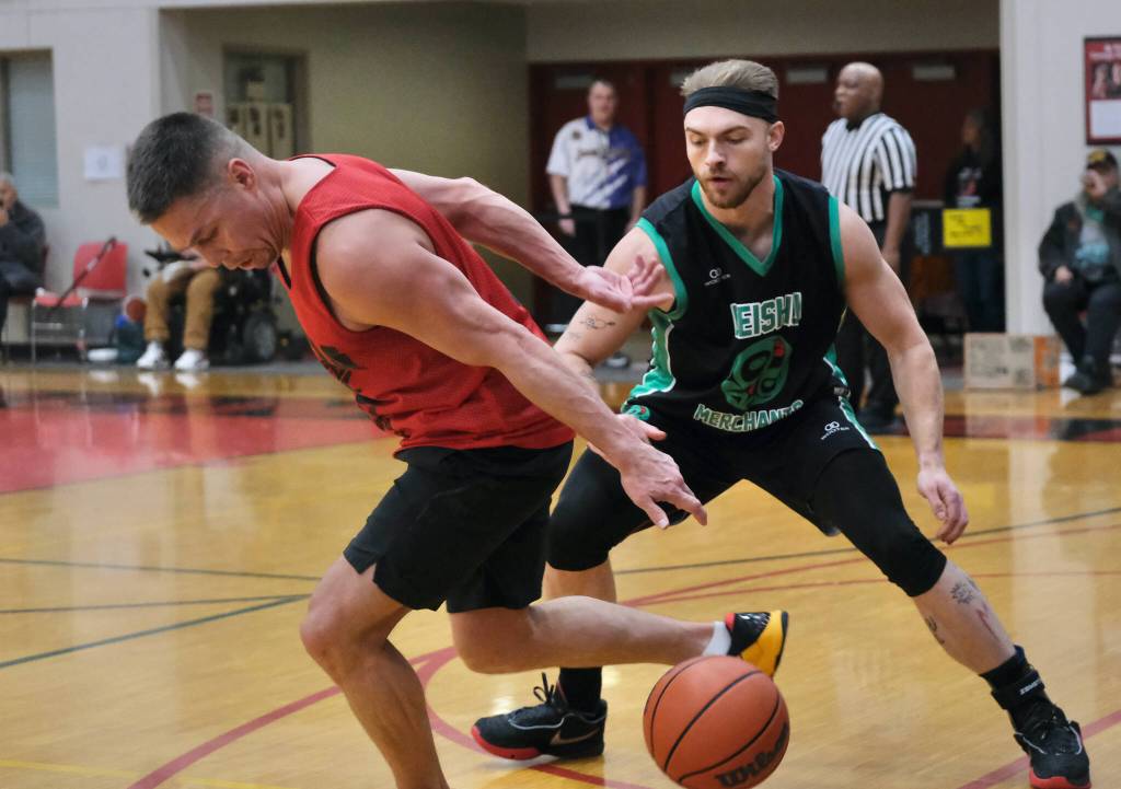 Hydaburgs Vinny Edenshaw dribbles behind his back to escape pressure from Haines Chevy Fowler during Haines 85-60 B Bracket elimination game win Thursday at the 76th Annual Juneau Lions Club Gold Medal Basketball Tournament in Juneau-Douglas High School: Yadaa.at Kalés George Houston Gymnasium. (Klas Stolpe / Juneau Empire)