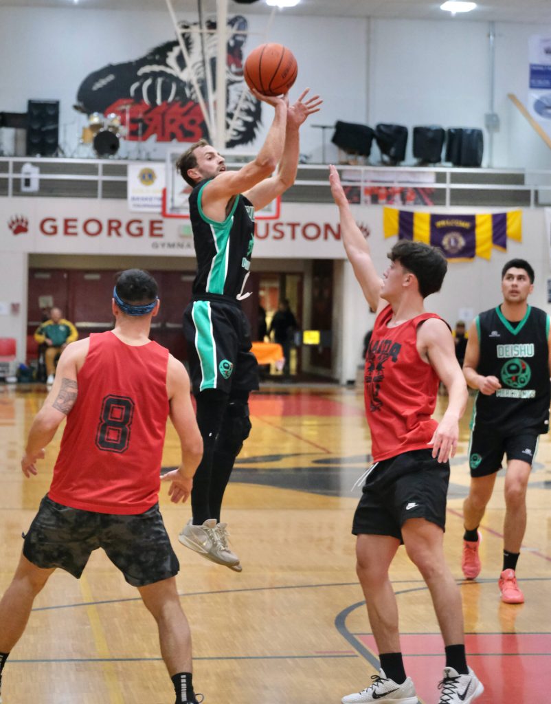 Haines Kyle Rush shoots over Hydaburgs Claude Young (8) and Trevor Olsen during Haines 85-60 B Bracket elimination game win Thursday at the 76th Annual Juneau Lions Club Gold Medal Basketball Tournament in Juneau-Douglas High School: Yadaa.at Kalés George Houston Gymnasium. (Klas Stolpe / Juneau Empire)