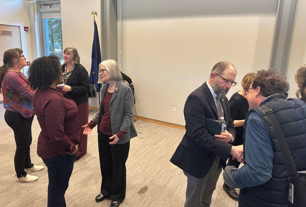 State Rep. Sara Hannan (background left), Rep. Andi Story (center) and Sen. Jesse Kiehl (right) talk with constituents following a town hall with the all-Democratic local delegation Thursday night at the Mendenhall Valley Public Library. (Mark Sabbatini / Juneau Empire)