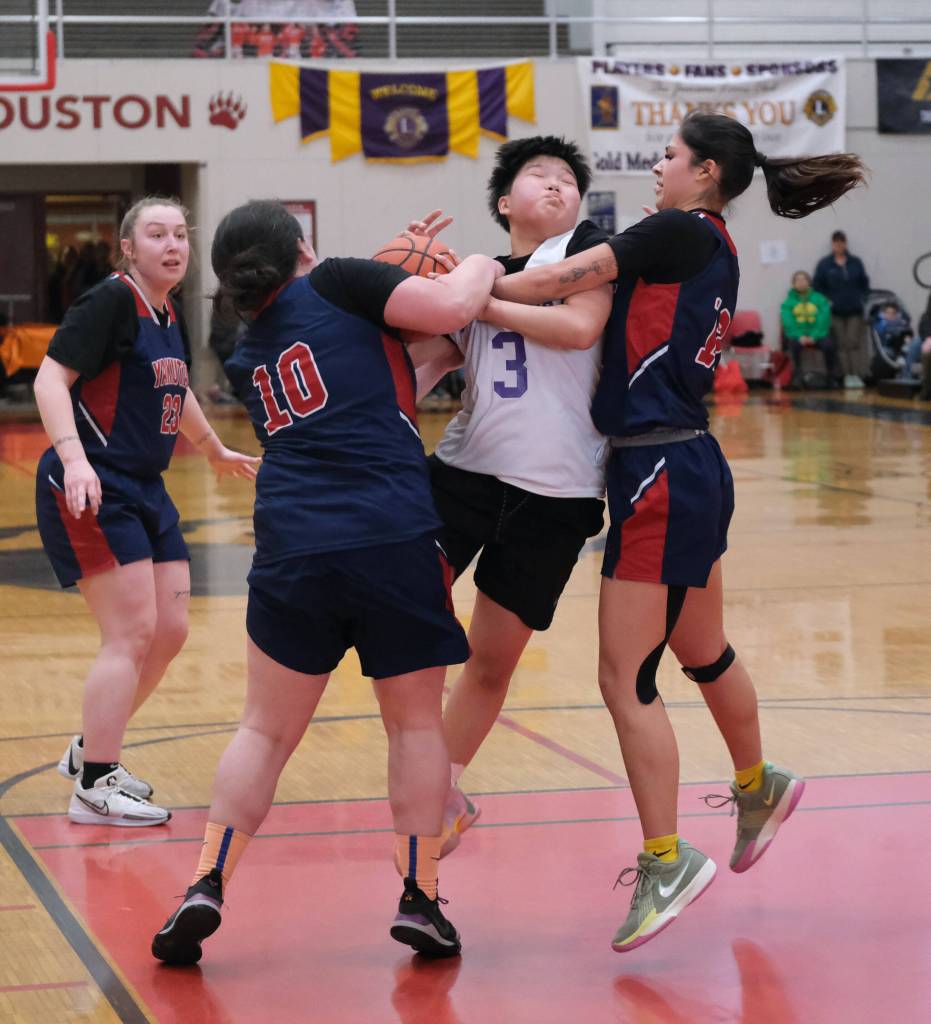 Hooper Bays Susie Long (3) is fouled by Yakutats Nadine Fraker (10) and Trinity Jakcson (12) Friday during Hooper Bays 60-58 Womens Bracket elimination game win over Yakutat at the 76th Annual Juneau Lions Club Gold Medal Basketball Tournament in Juneau-Douglas High School: Yadaa.at Kalés George Houston Gymnasium. (Klas Stolpe / Juneau Empire)