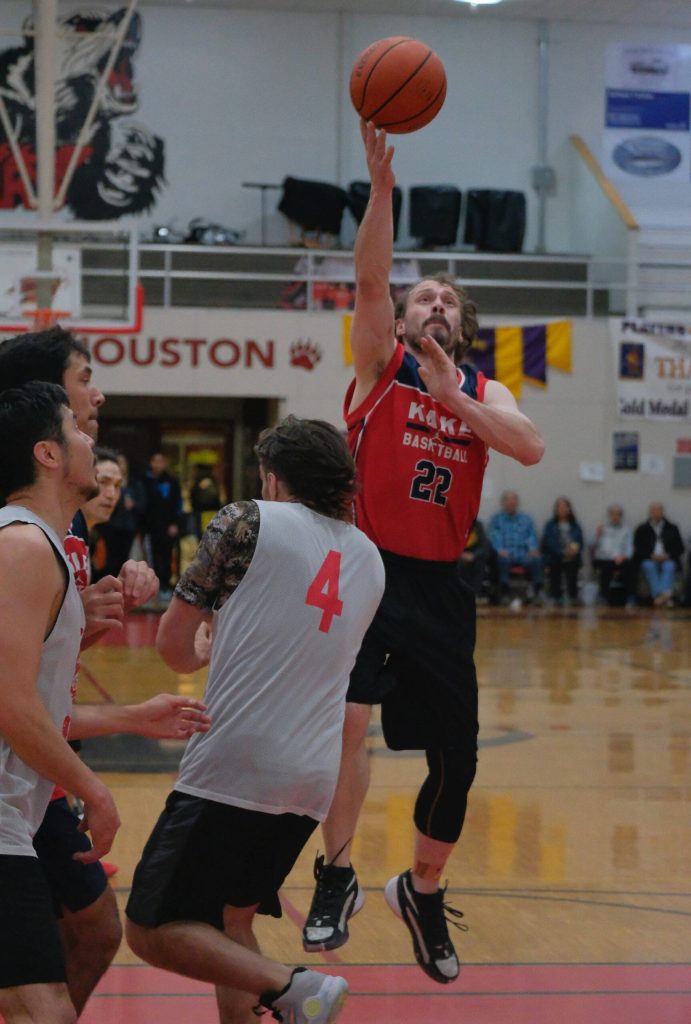 Kakes Trevor Rostad (22) scores over Hydaburgs Don Alander (4) during Hydaburgs 91-43 C Bracket elimination game win Friday at the 76th Annual Juneau Lions Club Gold Medal Basketball Tournament in Juneau-Douglas High School: Yadaa.at Kalés George Houston Gymnasium. (Klas Stolpe / Juneau Empire)