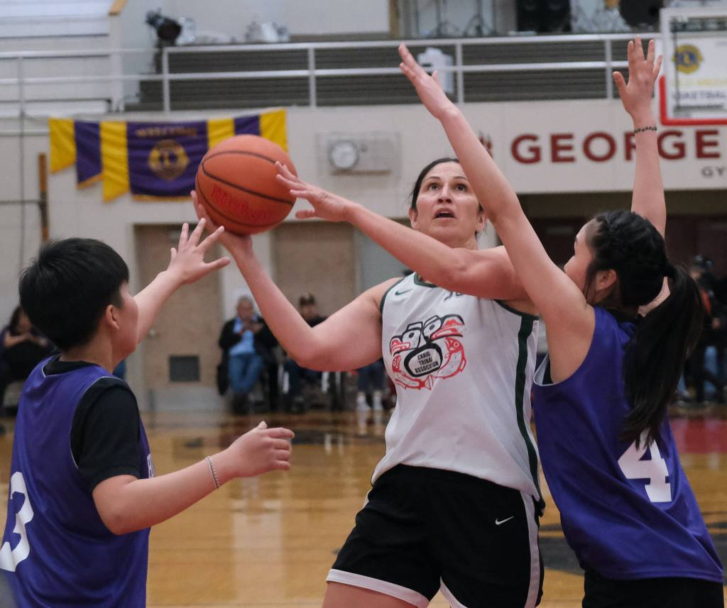 Craigs Tina Steffen (30) shoots over Hooper Bays Susie Long (3) and Mary Long (4) during the Womens Bracket Championship on Saturday at the 76th Annual Juneau Lions Club Gold Medal Basketball Tournament in Juneau-Douglas High School: Yadaa.at Kalés George Houston Gymnasium. (Klas Stolpe / Juneau Empire)