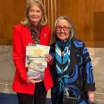 U.S. Sen. Lisa Murkowski (R-Alaska, left) and Sealaska Heritage Institute president Rosita Ḵaaháni Worl (right) stand together in Washington, D.C. Murkowski holds books from the Baby Raven Reads series. (Photo courtesy of Sealaska Heritage Institute)