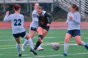 Juneau-Douglas High School: Yadaa.at Kalé freshman Ayla Erickson (16) blasts a shot through three Eagle River defenders during the Crimson Bears 3-0 win over the Wolves on Friday at Adair Kennedy Field. (Klas Stolpe / Juneau Empire)