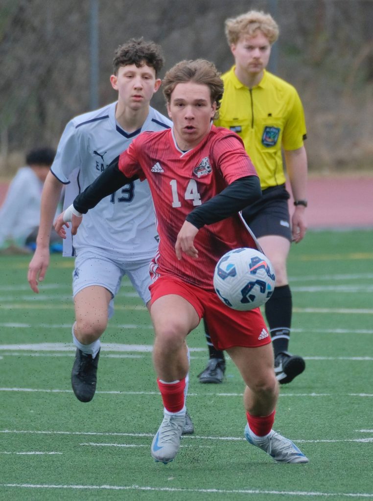 Juneau-Douglas High School: Yadaa.at Kalé senior Kai Ciambor (14) moves the ball against Eagle River during the Crimson Bears 12-0 win over the Wolves on Saturday at Adair Kennedy Field. (Klas Stolpe / Juneau Empire)