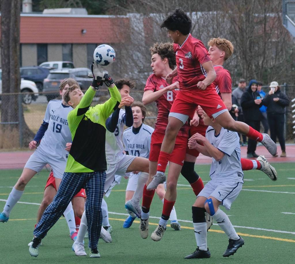 Juneau-Douglas High School: Yadaa.at Kalé junior Jesper Bennetsen (8), junior Noah Ault (3) and senior Reed Maier play a ball in the Eagle River box during the Crimson Bears 12-0 win over the Wolves on Saturday at Adair Kennedy Field. (Klas Stolpe / Juneau Empire)