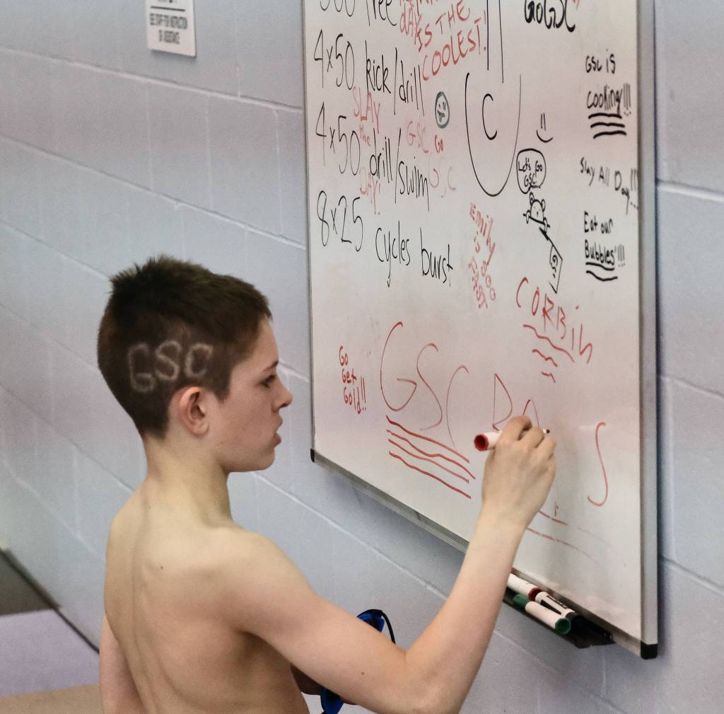 GSC swimmer Oliver Albrecht writes on the team inspiration board during the 2025 Savannah Cayce Southeast Age Group Championships at the Dimond Park Aquatic Center. (Klas Stolpe / Juneau Empire)